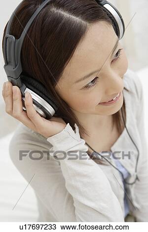 View of a young woman using headphone View Large Photo Image Stock Image - View of a young woman using headphone. Fotosearch