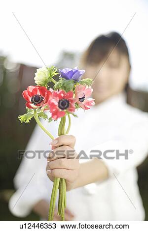 Stock Image - Woman with flowers in foreground. Fotosearch