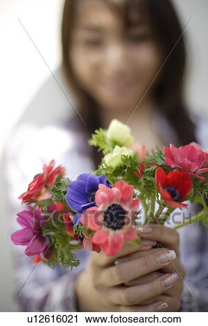 Woman with flowers in foreground View Large Photo Image Stock Image - Woman with flowers in foreground. Fotosearch