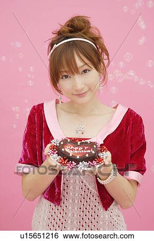 Portrait of a teenage girl holding a cake View Large Photo Image Stock Photograph - Portrait of a teenage girl holding a cake. Fotosearch