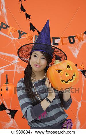 Portrait of teenage girl holding jack-o-lantern View Large Photo Image Stock Photo - Portrait of teenage girl holding jack-o-lantern. Fotosearch