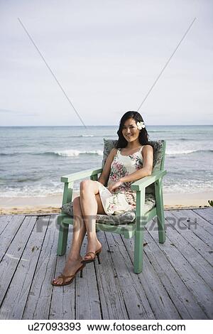 A woman sitting on chair at beach View Large Photo Image Stock Image - A woman sitting on chair at beach. Fotosearch