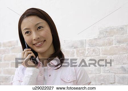 A young woman using cellphone View Large Photo Image Stock Photo - A young woman using cellphone. Fotosearch