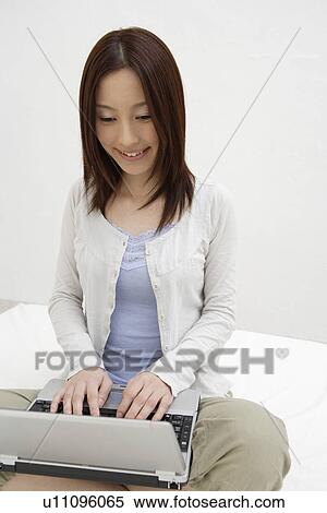 View of a cheerful woman using laptop View Large Photo Image Stock Photography - View of a cheerful woman using laptop. Fotosearch