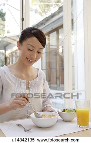 View of a young woman having breakfast View Large Photo Image Stock Photography - View of a young woman having breakfast. Fotosearch