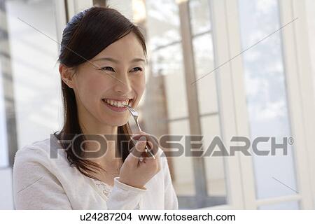 View of a young woman holding a fork View Large Photo Image Picture - View of a young woman holding a fork. Fotosearch