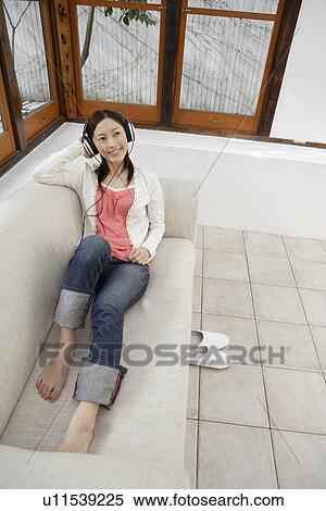 Stock Photography - View of a young woman listening to music. Fotosearch