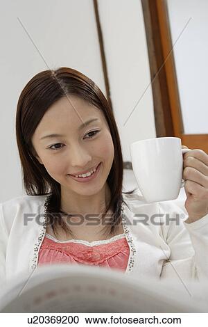 View of a young woman sitting on a sofa View Large Photo Image Stock Image - View of a young woman sitting on a sofa. Fotosearch