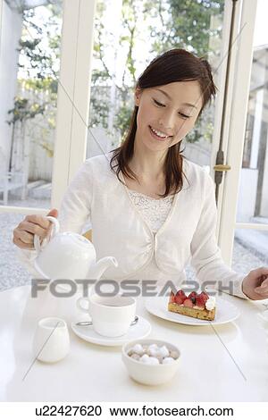 A young woman pouring tea from teapot View Large Photo Image Stock Image - A young woman pouring tea from teapot. Fotosearch
