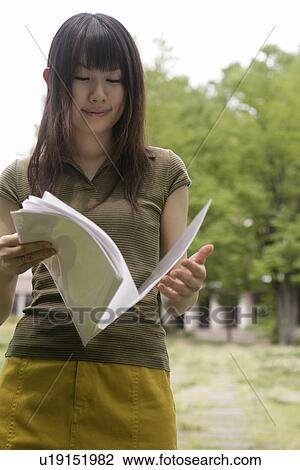 A young woman smiles as she goes through the files and papers View Large Photo Image Stock Image - A young woman smiles as she goes through the files and papers. Fotosearch