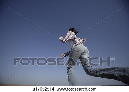 Low angle view of a young woman running View Large Photo Image Picture - Low angle view of a young woman running. Fotosearch