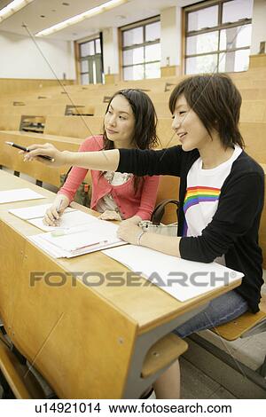 Two young women at classroom View Large Photo Image Picture - Two young women at classroom. Fotosearch