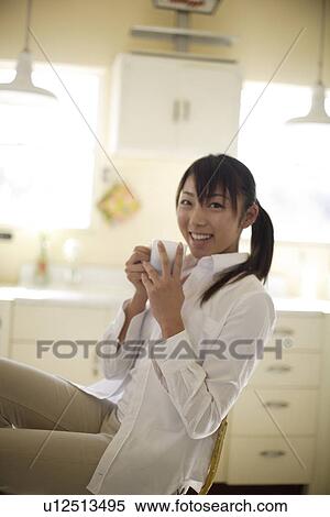 View of a cheerful woman holding cup View Large Photo Image Stock Photography - View of a cheerful woman holding cup. Fotosearch