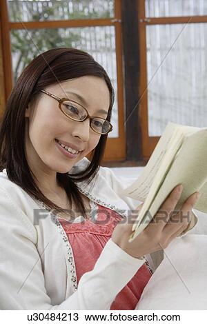 View of a young woman reading a book View Large Photo Image Stock Image - View of a young woman reading a book. Fotosearch