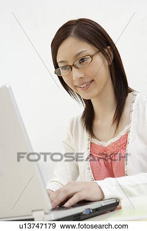 Stock Photo - View of a young woman using laptop. Fotosearch