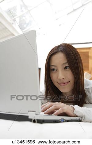 View of a young woman using laptop View Large Photo Image Stock Photograph - View of a young woman using laptop. Fotosearch