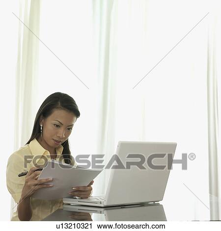Businesswoman holding papers in her hand and reading View Large Photo Image Stock Image - Businesswoman holding papers in her hand and reading. Fotosearch
