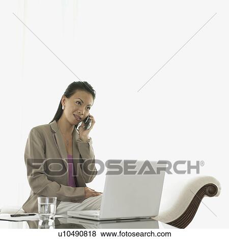 Stock Photo - Businesswoman talking on a mobile phone. Fotosearch