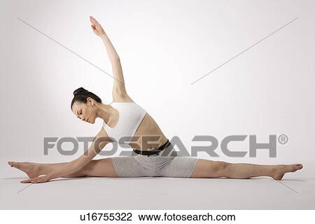 View of a young woman stretching on the floor View Large Photo Image Stock Image - View of a young woman stretching on the floor. Fotosearch