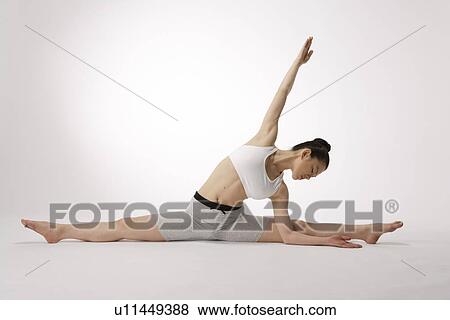 View of a young woman stretching on the floor View Large Photo Image Stock Photo - View of a young woman stretching on the floor. Fotosearch