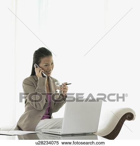 Stock Photography - Businesswoman talking on a mobile phone smiling. Fotosearch
