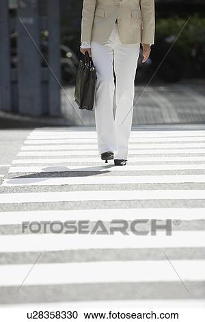 Businesswoman walking on a crosswalk, portrait View Large Photo Image Stock Image - Businesswoman walking on a crosswalk, portrait. Fotosearch