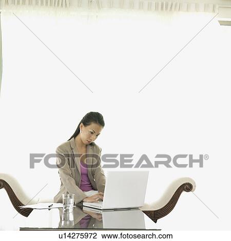 Businesswoman working on a laptop View Large Photo Image Stock Image - Businesswoman working on a laptop. Fotosearch