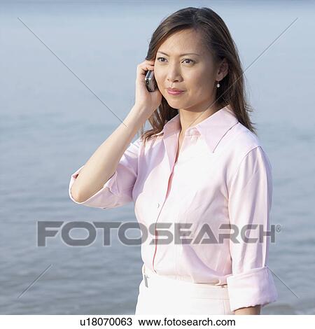 Stock Image - Mid adult woman talking on a mobile phone. Fotosearch