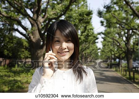 Picture - Portrait of a young woman talking on mobile phone. Fotosearch