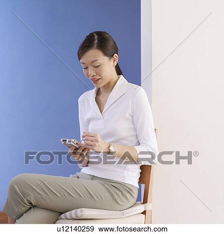 Young woman holding a personal data assistant View Large Photo Image Stock Photo - Young woman holding a personal data assistant. Fotosearch