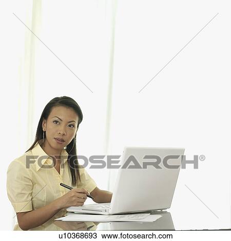 Young woman sitting in front of a laptop View Large Photo Image Stock Image - Young woman sitting in front of a laptop. Fotosearch