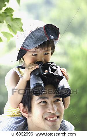 A boy on father's shoulder, looking into binoculars View Large Photo Image Stock Photograph - A boy on father's shoulder, looking into binoculars. Fotosearch