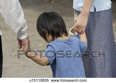 A boy standing between mother and father View Large Photo Image Stock Photography - A boy standing between mother and father. Fotosearch
