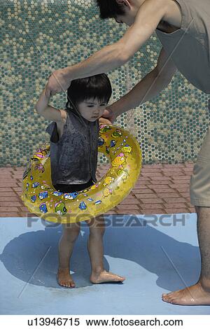 A boy with a float at pool with his father View Large Photo Image Stock Photography - A boy with a float at pool with his father. Fotosearch