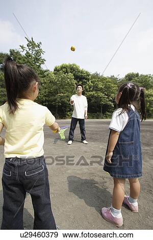 Stock Photo - Two girls playing catch with father. Fotosearch