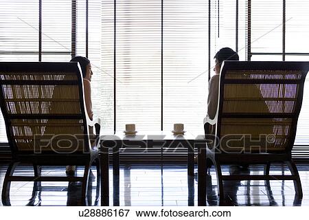 Stock Photo - Couple sitting beside the window. Fotosearch