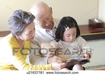 Girl with grandparents looking at brochure View Large Photo Image Stock Image - Girl with grandparents looking at brochure. Fotosearch