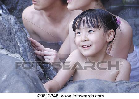 Stock Photo - Girl with parents in hot tub, smiling. Fotosearch