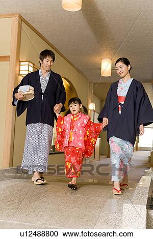 Stock Image - Girl with parents walking in Yukata, hand in hand. Fotosearch