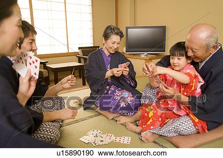 Stock Image - Multi-generation family playing cards in Yukata. Fotosearch