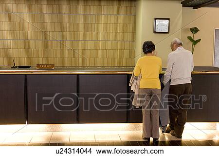 Picture - Senior couple at the reception in the hotel. Fotosearch