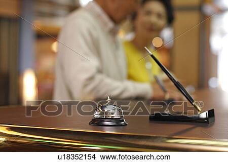 Picture - Senior couple checking into hotel, differential focus. Fotosearch