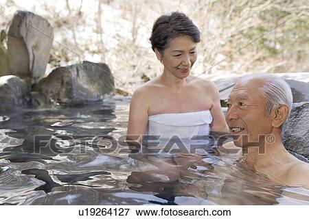 Stock Photo - Senior couple in hot tub, smiling. Fotosearch