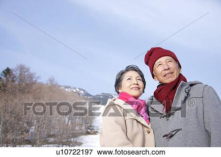 Senior couple in winter, smiling and looking up View Large Photo Image Stock Photo - Senior couple in winter, smiling and looking up. Fotosearch