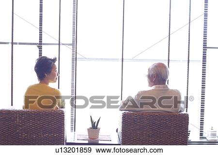 Senior couple sitting beside the window View Large Photo Image Stock Photo - Senior couple sitting beside the window. Fotosearch