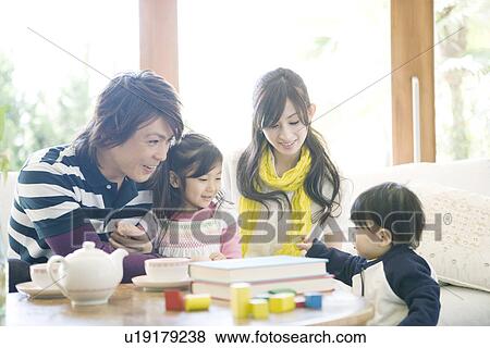 Stock Photo - Family of Four in the Living Room. Fotosearch
