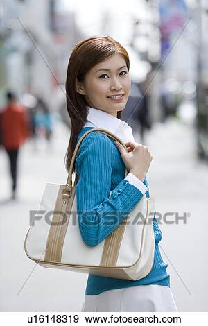 Stock Photo - A Woman Standing on the Street. Fotosearch