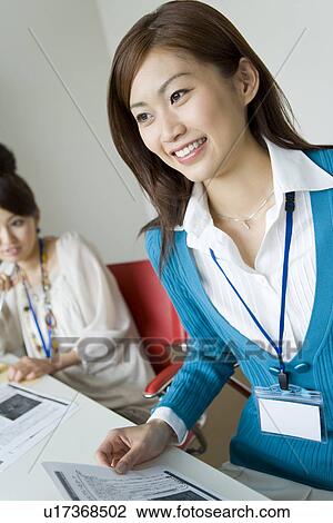 Stock Image - A Woman Taking a Note in a Meeting. Fotosearch