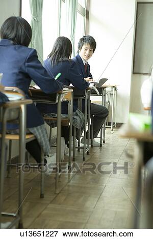 Stock Photo - High school students in classroom, boy looking back. Fotosearch