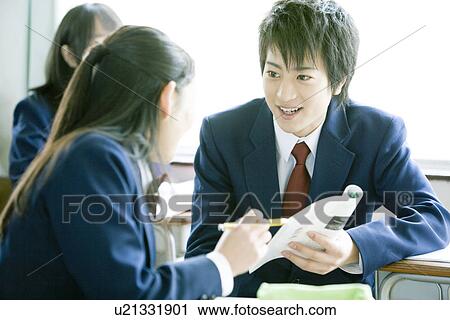 Stock Image - High school students in classroom, smiling. Fotosearch